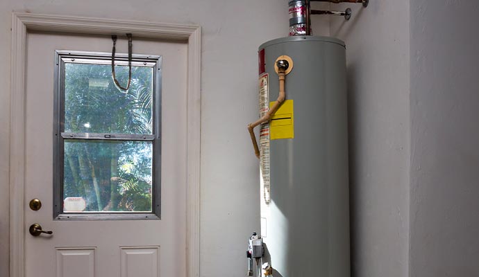 A residential tank-style water heater installed in a utility room A residential tank-style water heater installed in a utility room